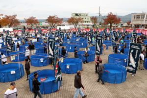 水槽がたくさん並べられた会場の画像