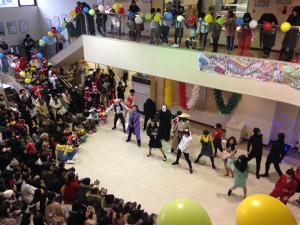 1階エントランスホールで大勢の観客を前に仮装して踊るダンスサークル生徒の画像