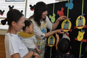 お面を選ぶ親子の画像