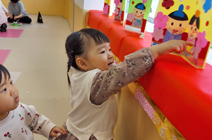 手作りのひなまつりの飾りを見る子どもたちの画像