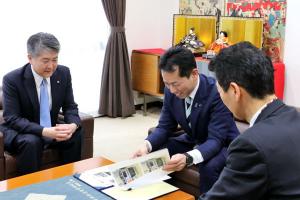 寄贈いただいた機器の写真を笑顔で見る宮崎市長の画像
