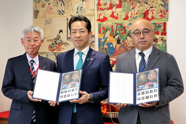 関係者とフレーム切手をもって記念撮影をする宮崎市長の画像