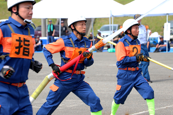 真剣な表情で放水を行う消防団員の画像
